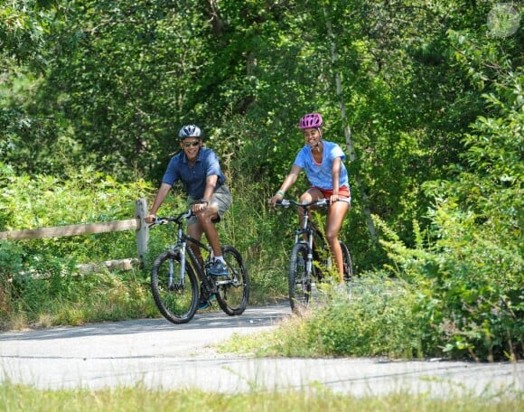 Barack Obama en sortie vélo avec sa fille Malia pendant ses vacances présidentielles sur l'île de Martha's Vineyard, le 16 août 2013.