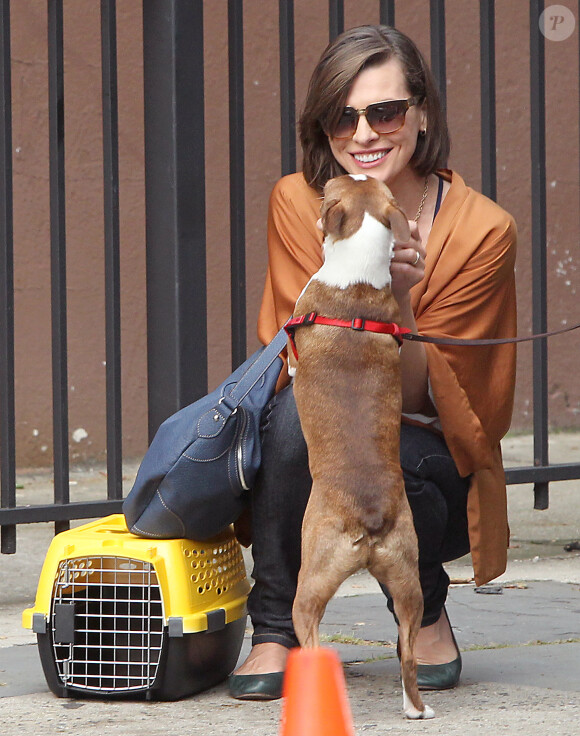 Milla Jovovich joue avec un petit chien sur le tournage de Cymbeline à Brooklyn, New York, le 28 août 2013.