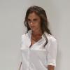 Victoria Beckham, ultra chic en chemise blanche, pantalon noir et souliers Manolo Blahnik, salue son public à l'issue de son défilé printemps-été 2014. New York, le 8 septembre 2013.