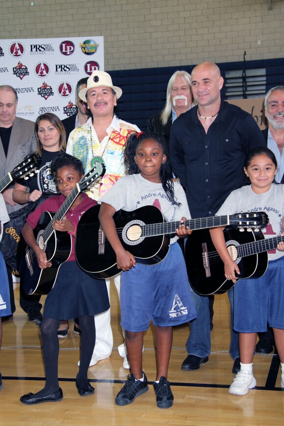Carlos Santana et Andre Agassi lors d'une donation d'instruments de musique en compagnie des enfants étudiant au Andre Agassi College Preparatory Academy à Las Vegas, le 9 septembre 2013