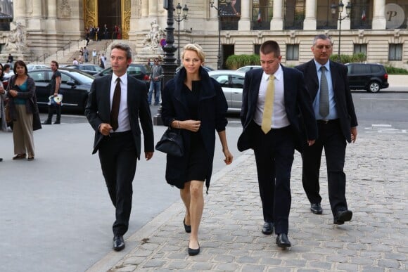 La princesse Charlene de Monaco, accompagnée de ses gardes du corps et de Peter Kriemler, PDG d'Akris, arrive à la galerie sud est du Grand Palais pour assister au défilé printemps-été 2014 de la griffe suisse. Paris, le 29 septembre 2013.