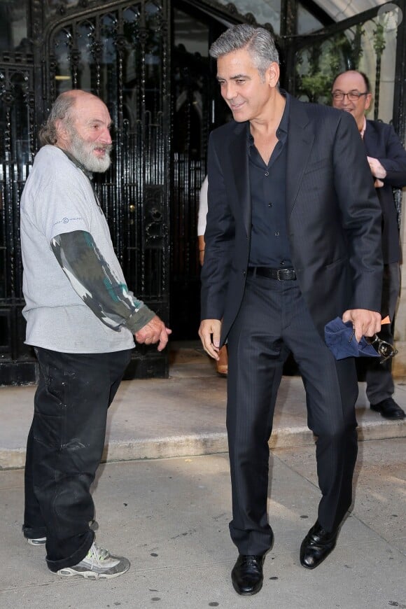 George Clooney quittant le déjeuner en l'honneur du film Gravity à New York le 2 octobre 2013. Il croise le célèbre Radio Man avec qui il a bavardé un peu