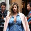 Kim Kardashian quitte le restaurant La Société, habillée d'un manteau Céline porté à l'italienne, d'un look en jean et de souliers Saint Laurent. Paris, le 1er octobre 2013.