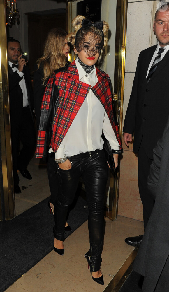 Rita Ora sort de l'hôtel Bristol avec Cara Delevingne, habillée d'une voilette Maison Michel, d'une veste tartan Karl Lagerfeld, d'un pantalon en cuir Balmain et de souliers Christian Louboutin. Paris, le 1er octobre 2013.