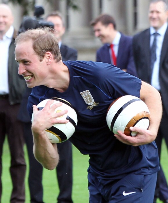 Le prince William joue au foot lors d'un match organisé pour le 150e anniversaire de la Fédération anglaise le 7 octobre 2013 au palais de Buckingham.