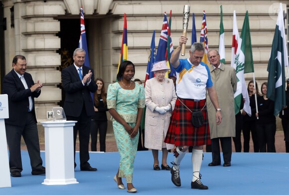 Elizabeth II lors de la cérémonie de lancement, le 9 octobre 2013 à Buckingham Palace, du relais du Bâton de la reine pour les 20e Jeux du Commonwealth, qui se dérouleront à Glasgow en Ecosse à partir du 24 juillet 2014.