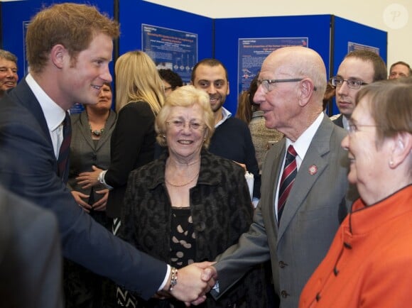 Le prince Harry salue Sir Bobby Charlton le 17 octobre 2013 lors de l'inauguration d'un centre d'études sur les blessures par explosion de la légion britannique à l'Imperial College de Londres.