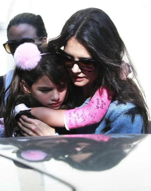 Katie Holmes accompagne sa fille Suri, qui a un plâtre rose au bras droit, à l'école à New York. Le 1er octobre 2013.