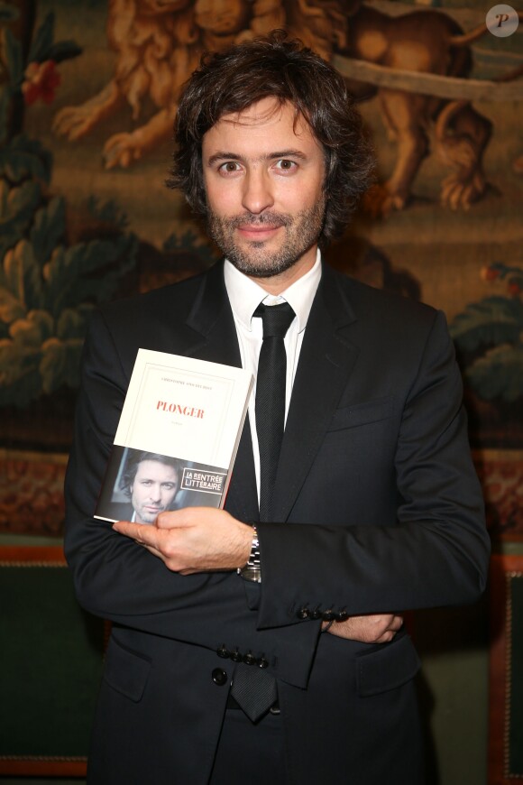 Le journaliste et écrivain Christophe Ono-dit-Biot pose avec son livre "Plonger"qui vient de lui valoir Grand prix du roman de l'Académie française à Paris, le 24 Octobre 2013.