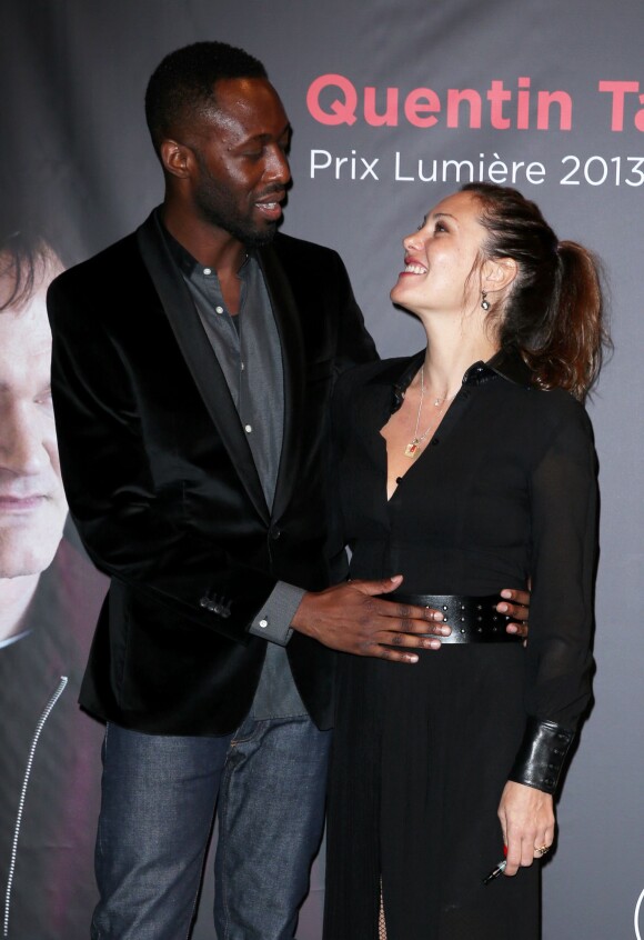 Thomas Ngijol posant délicatement sa main sur le ventre de  Karole Rocher lors de la remise du Prix Lumière 2013 à Quentin Tarantino à Lyon le 18 octobre 2013 : le signe d'un heureux événement à venir ?