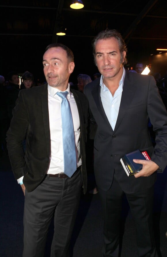 Michel Flaury, directeur de la brigade de recherche et d'intervention (BRI), et Jean Dujardin lors de la remise du prix polar Quai des Orfèvres 2014 à Hervé Jourdain, capitaine à la Crim', pour son livre Le sang de la trahison, à Paris, le 12 novembre 2013.