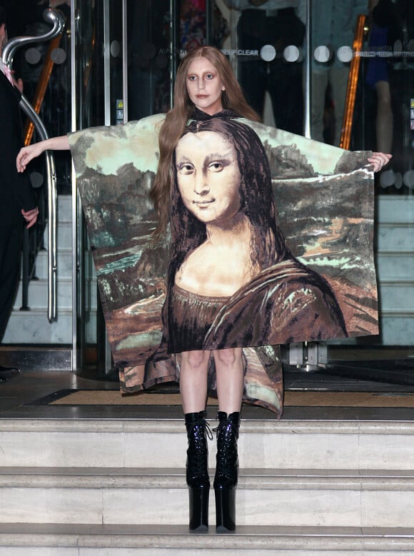Lady Gaga, habillée d'une robe à l'effigie de Mona Lisa et chaussée de bottines à plateformes Pleaser, quitte l'hôtel Langham. Londres, le 4 décembre 2013.