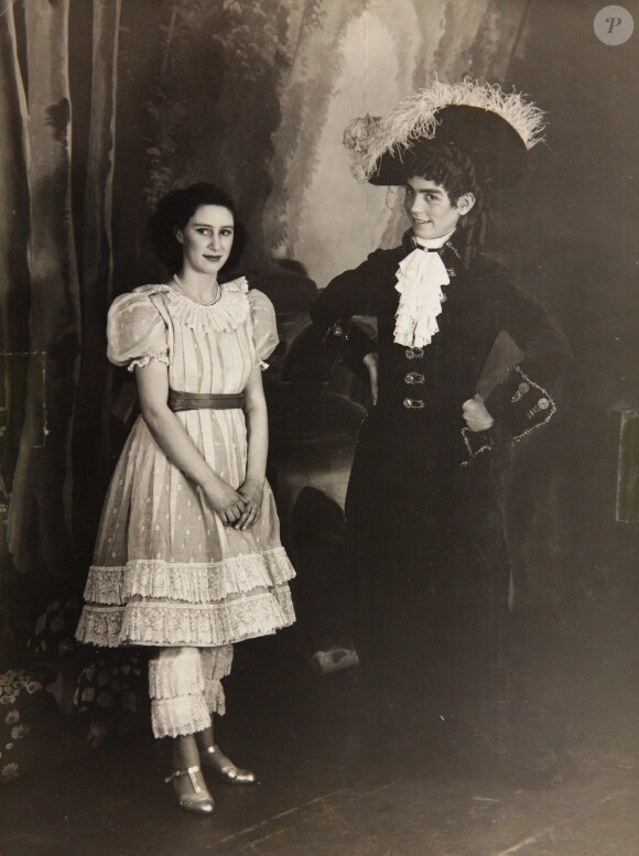 La princesse Margaret et Cyril Woods dans Old Mother Red Riding Boots, en 1944. De 1941 à 1944, les princesses Elizabeth (future reine Elizabeth II) et Margaret donnaient en soutien de l'effort de guerre des pantomimes royales au château de Windsor avec leur ami de la Royal School de Windsor Cyril Woods et sous la direction du principal Hubert Tannar.