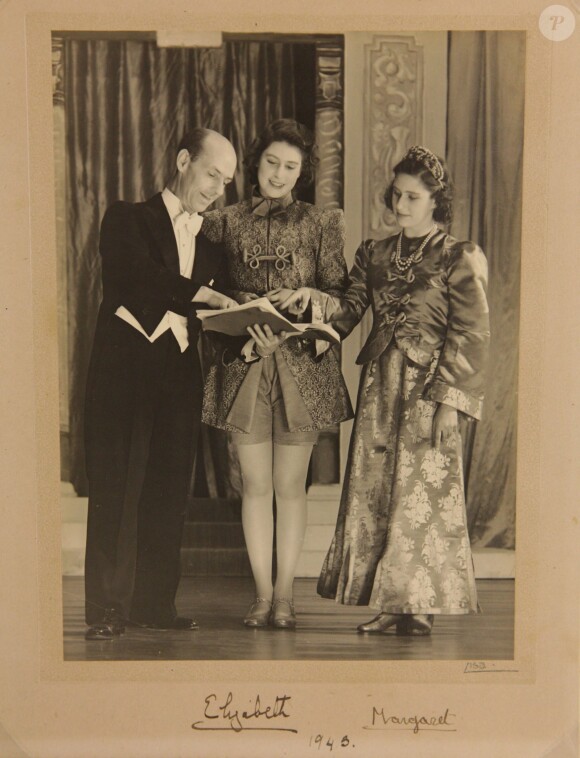 Les princesses Elizabeth et Margaret dans une photo signée de leur représentation d'Aladddin, en 1943. De 1941 à 1944, les princesses Elizabeth (future reine Elizabeth II) et Margaret donnaient en soutien de l'effort de guerre des pantomimes royales au château de Windsor avec leur ami de la Royal School de Windsor Cyril Woods et sous la direction du principal Hubert Tannar.