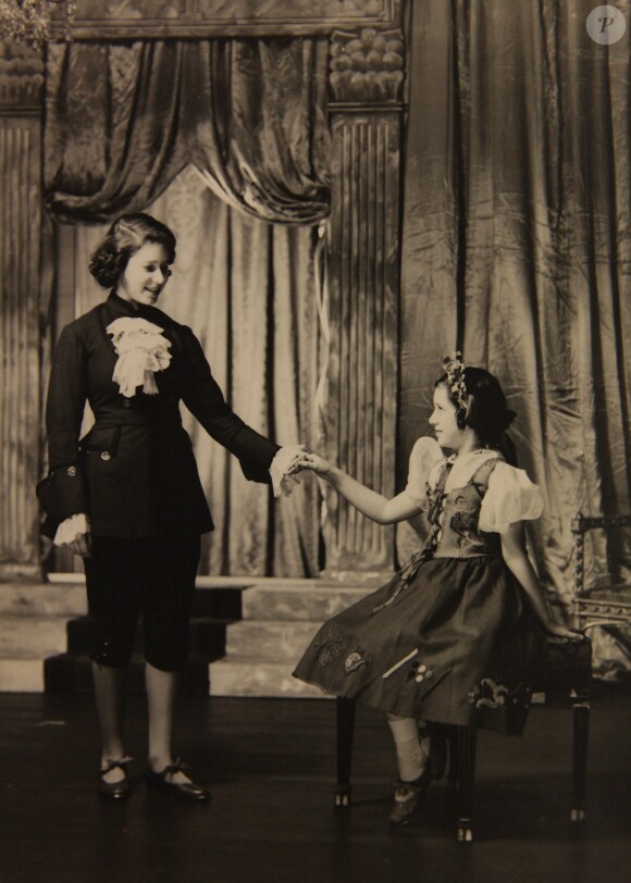 Les princesses Elizabeth, en prince, et Margaret jouant Cendrillon à Noël 1941. De 1941 à 1944, les princesses Elizabeth (future reine Elizabeth II) et Margaret donnaient en soutien de l'effort de guerre des pantomimes royales au château de Windsor avec leur ami de la Royal School de Windsor Cyril Woods et sous la direction du principal Hubert Tannar.