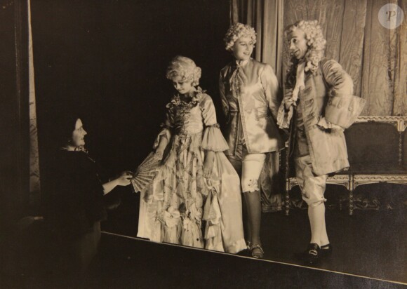 La reine mère face aux princesses Margaret et Elizabeth lors de leur représentation d'Aladdin à Noël 1943. De 1941 à 1944, les princesses Elizabeth (future reine Elizabeth II) et Margaret donnaient en soutien de l'effort de guerre des pantomimes royales au château de Windsor avec leur ami de la Royal School de Windsor Cyril Woods et sous la direction du principal Hubert Tannar.