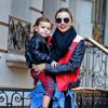 Miranda Kerr, ultrastylée avec son fils Flynn, porte des lunettes Prada, un perfecto Acne (modèle Merci Contrast), une chemise Chloé nouée à la taille, un slim et des bottines noires. New York, le 16 novembre 2013.