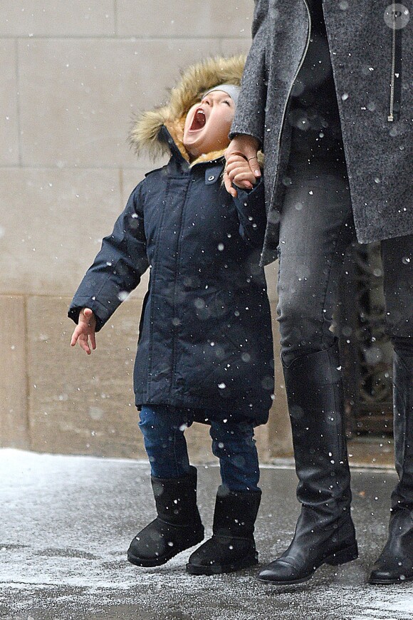 Flynn tente de goûter des flocons de neige en quittant l'appartement de sa mère, Miranda Kerr. New York, le 14 décembre 2013.