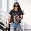 Kylie Jenner en pleine séance shopping à Beverly Hills, porte des lunettes Céline, un t-shirt merchandising du Yeezus Tour de son futur beau-frère Kanye West (par l'artiste Wes Lang), un jean destroy Topshop, un sac Céline (modèle Boston en mini) et des bottines Chanel. Los Angeles, le 15 décembre 2013.