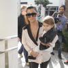 Kourtney Kardashian, maman stylée avec sa fille Penelope à Beverly Hills, porte des lunettes Céline, un chemisier décolleté Asos, un pantalon en cuir, un sac Chanel et des sandales Alexander Wang (modèle Antonia). Los Angeles, le 16 décembre 2013.