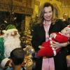 Valérie Trierweiler avec le petit Killian déguisé en père Noël lors d'un événement de charité donné par le Secours Populaire à Brive-la-Gaillarde, le 21 décembre 2013.