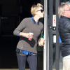 Charlize Theron quitte un café Starbucks à Los Angeles, habillée d'un sweater zippé porté sur une chemise bleue à carreaux, d'un pantalon Current/Elliott et de baskets Nike. Le 4 janvier 2014.