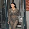 Kim Kardashian quitte l'appartement de son fiancé Kanye West, habillée d'une robe Rachel Roy (collection automne 2013) et de sandales Tom Ford. New York, le 25 mars 2014.