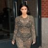 Kim Kardashian quitte l'appartement de son fiancé Kanye West, habillée d'une robe Rachel Roy (collection automne 2013) et de sandales Tom Ford. New York, le 25 mars 2014.
