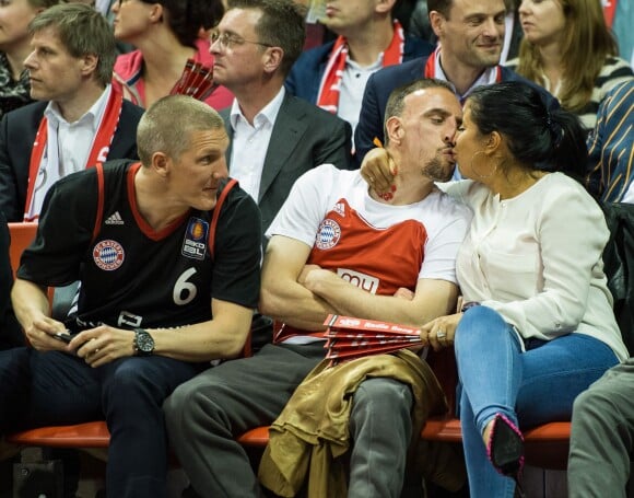Franck Ribéry et sa femme Wahiba s'embrassant sous le regard de Bastian Schweinsteiger lors de la rencontre du Top 16 de l'Euroligue entre le Bayern Munich et le Maccabi Tel Aviv, le 3 avril 2014 à Munich.