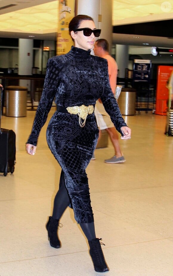 Kim Kardashian, ultrachic en robe Balmain et bottines Tom Ford, arrive à l'aéroport de Miami. Le 14 avril 2014.