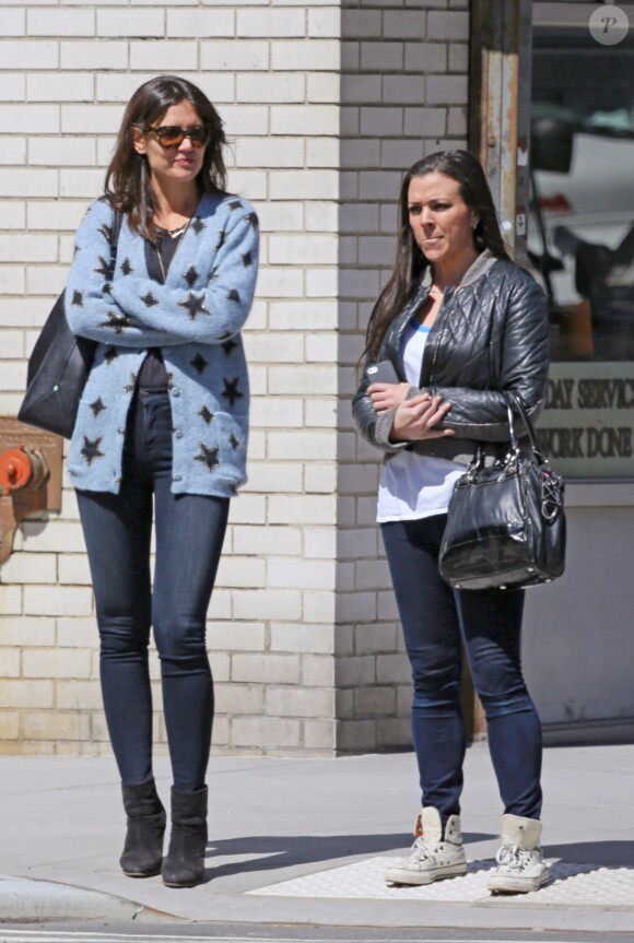 Katie Holmes et une amie se promènent à New York, le 16 avril 2014. Katie Holmes porte un gilet avec des étoiles et un jean slim, l'une de ses signatures lorsqu'elle ne porte pas son boyfriend jean.