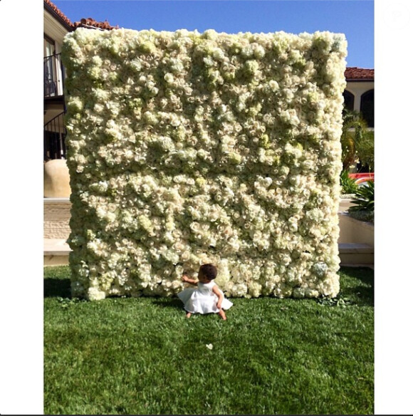 La petite North devant le mur de fleurs offert par Kanye West à Kim Kardashian le jour de la fête des mères, le 11 mai 2014. 
