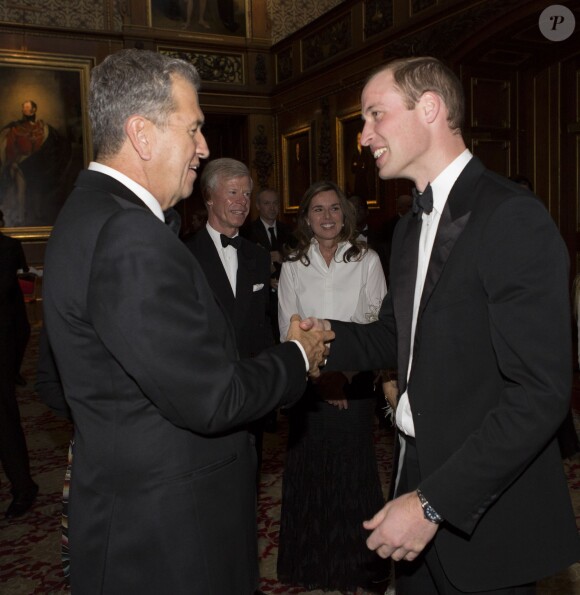 Le prince William salue Mario Testino, le 13 mai 2014 au château de Windsor, lors d'une soirée de bienfaisance au profit du Royal Marsden Hospital dont le duc de Cambridge est le président, organisée avec Ralph Lauren.