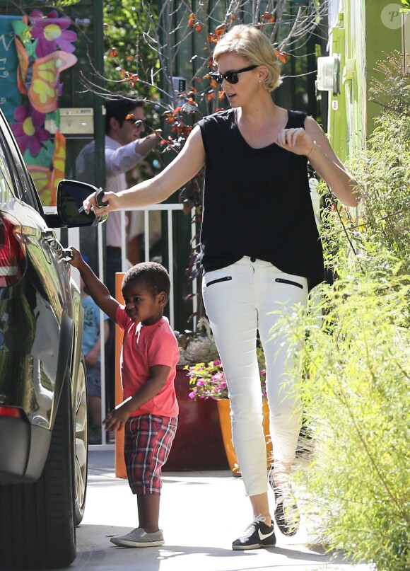Exclusif - Charlize Theron, aperçue avec son fils Jackson à Los Angeles, porte des lunettes Ray-Ban, un débardeur noir, un pantalon Current/Elliott et des baskets Nike (modèle Tenkay). Le 13 mai 2014.
