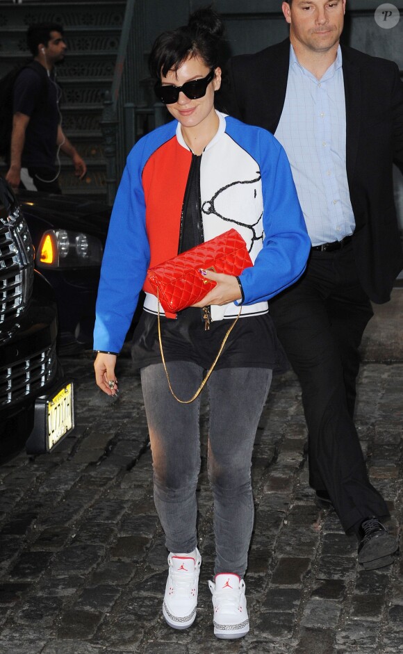 Lily Allen arrive à son hôtel à New York, habillée d'une veste Fay (collection automne-hiver 2014-15) à l'effigie de Snoopy, d'un sac rouge Chanel et de baskets Air Jordan III. New York, le 15 mai 2014.