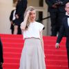 Amber Heard, habillée d'un t-shirt et d'une jupe Vionnet (collection printemps 2014), monte les marches du Palais des Festivals lors de la projection du film Deux jours, une nuit. Cannes, le 20 mai 2014.