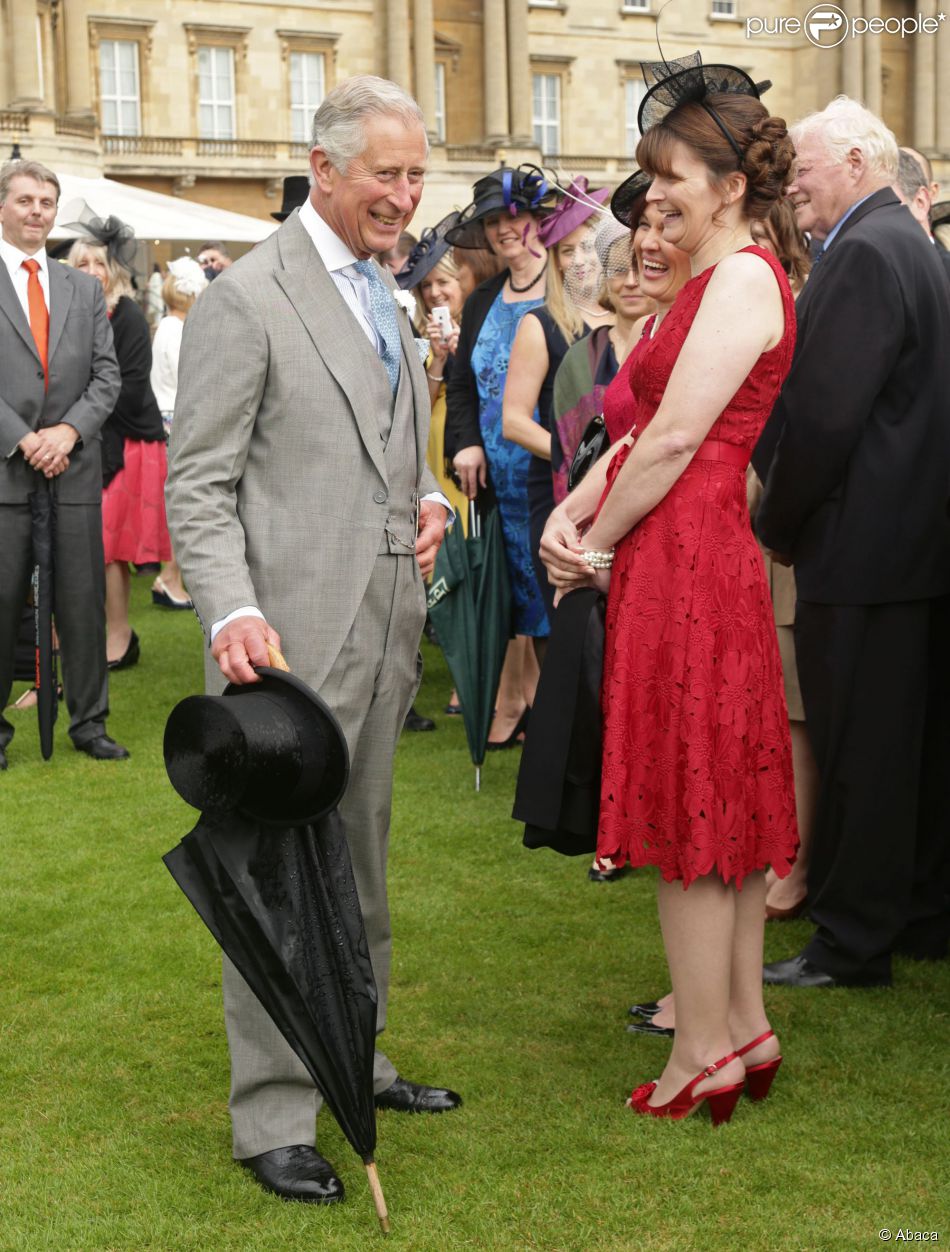 Le prince Charles profite d&#039;une éclaircie pour ranger son parapluie lors de la pluvieuse troisième garden party de l&#039;année organisée à Buckingham Palace le 3 juin 2014.