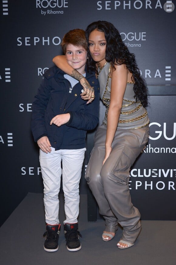 La chanteuse Rihanna pose avec un jeune fan chez Sephora sur l'avenue des Champs-Elysées à Paris, le 4 juin, 2014 pour le lancement de son parfum Rogue
