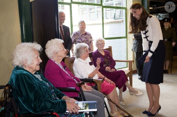 Kate Middleton, duchesse de Cambridge, en pleine discussion avec d'anciennes décodeuses le 18 juin 2014 à Bletchley Park, ancien centre de décryptage de codes pendant la Seconde Guerre mondiale où sa défunte grand-mère Valerie Glassborow oeuvra et qu'elle venait réouvrir après un an de travaux de rénovation.