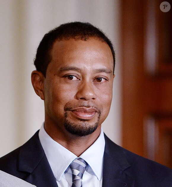 Tiger Woods esquisse un sourire lors d'une réception organisée à la Maison Blanche en l'honneur de l'équipe de la Presidents Cup, en compagnie de Barack Obama, le 24 juin 2014 à Washington