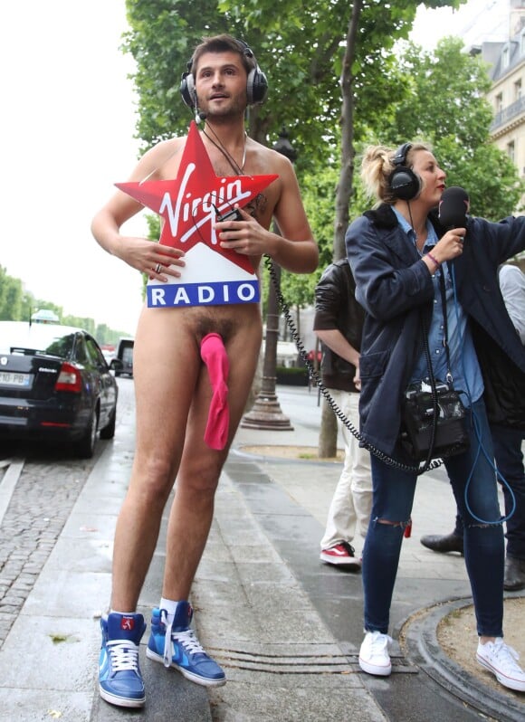 Christophe Beaugrand court nu sur l'avenue des Champs-Élysées à Paris le 28 mai 2014, au côté d'Emilie Picchereddu.
