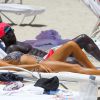 Le footballeur français Bacary Sagna et sa femme Ludivine profitent du soleil sur une plage à Miami le 18 juillet 2014