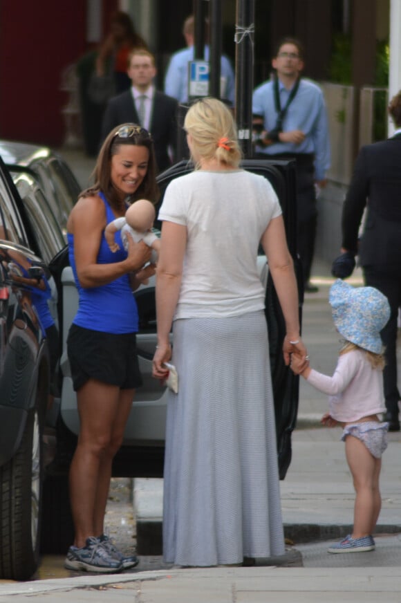 Exclusif - La superbe Pippa Middleton, un poupon dans les bras, discute avec une amie à Londres, le 14 juillet 2014.