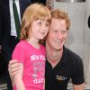 Le prince Harry pose avec la jeune Olivia Hanhock, 8 ans, totalement fan, en sortant de la BBC Radio 2 le 30 juillet 2014 après avoir enregistré une interview pour les Invictus Games.