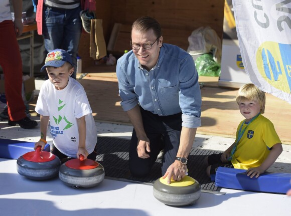 Le prince Daniel de Suède, ici en pleine initiation de curling, a accueilli près de 1 500 jeunes lors de la Journée du Sport Prince Daniel dans le parc du palais Haga, le 7 septembre 2014 à Stockholm