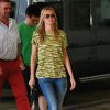 Heidi Klum à New York, porte des lunettes Tom Ford, un t-shirt à l'imprimé zèbre jaune, un jean Mother Denim et des sandales dorées Birkenstock. Le 31 août 2014.