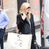 Kate Moss quitte une boutique Burberry à Londres, tout de noir vêtue avec un foulard léopard Saint Laurent et des chaussures Alaïa. Le 11 septembre 2014.