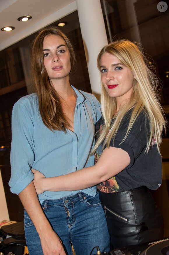 Louise Basilien et Anaïs Vandevyvere du groupe Les Plastiscines mixent dans la boutique Galliano lors de la Vogue Fashion Night Out 2014. Paris, le 16 septembre 2014.
