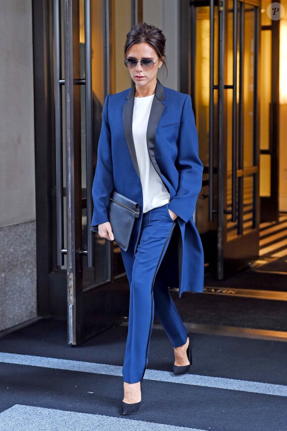 Victoria Beckham quitte un hôtel à New York, habillée d'un ensemble veste pantalon bleu royal, d'une pochette Victoria Beckham et de souliers Casadei. New York, le 25 septembre 2014.