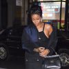 Rihanna à New York, porte un manteau Miu Miu, une petite robe noire Reformation, un sac Balenciaga (modèle Le Dix Cartable) et des baskets New Balance. Le 23 septembre 2014.